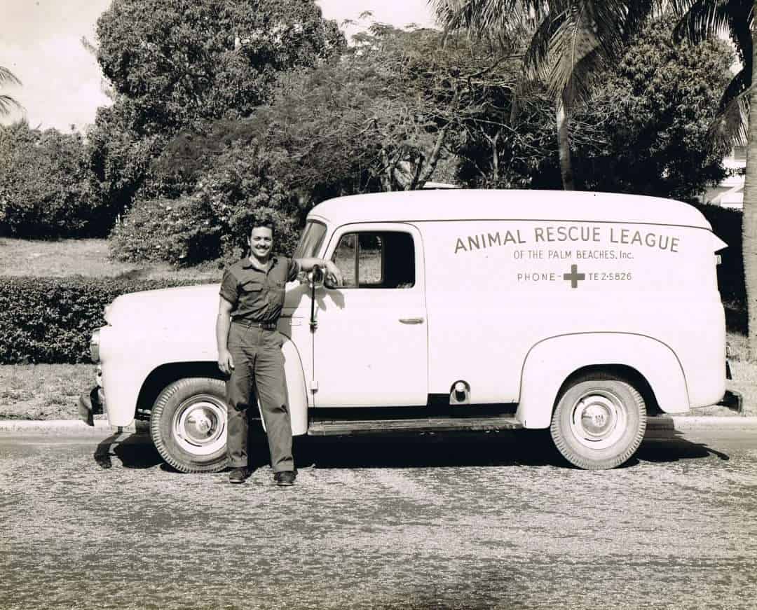 Voluntario de rescate de animales con camioneta de rescate antigua.