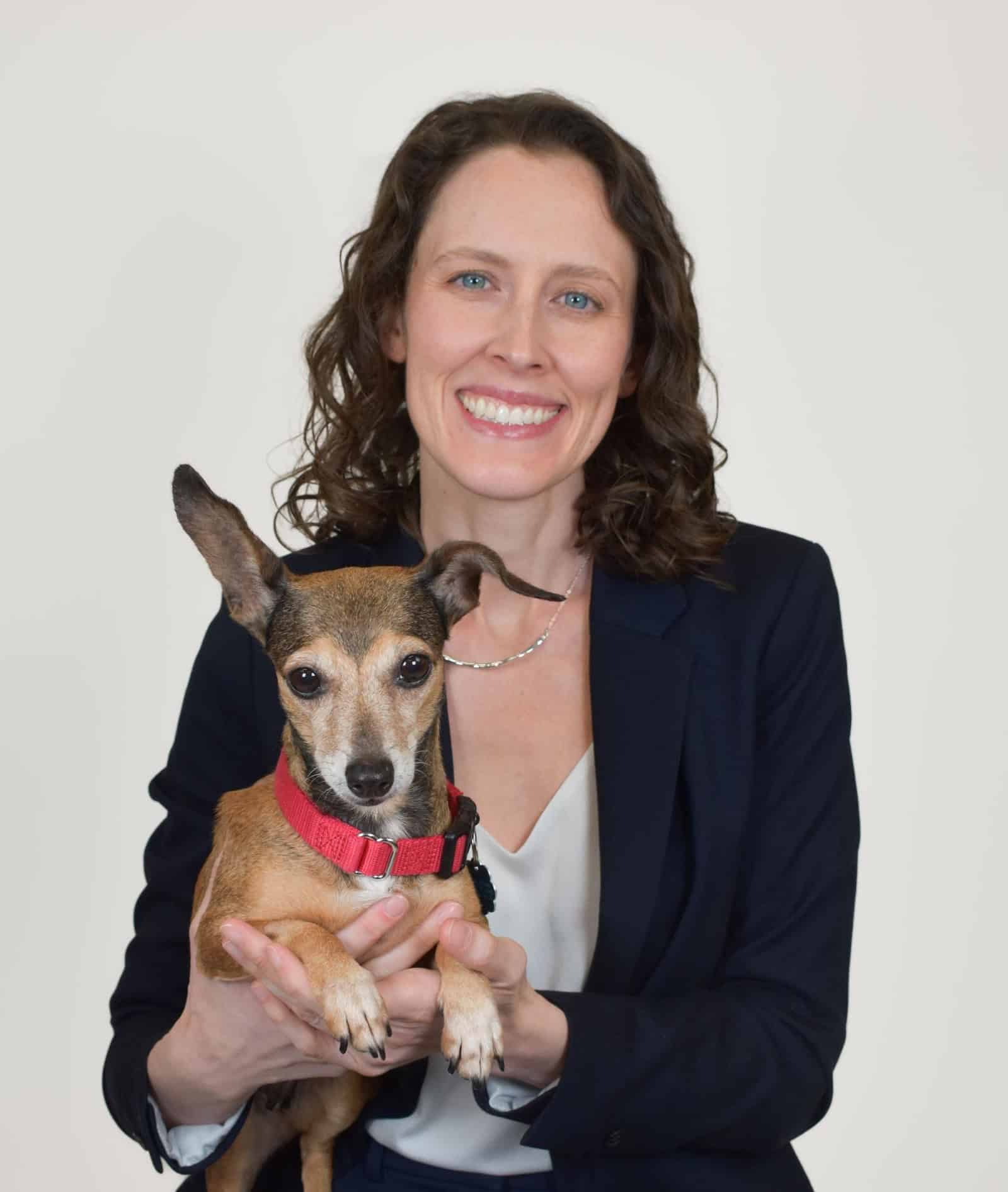 Mujer sosteniendo un perro pequeño en Peggy Adams Animal Rescue.