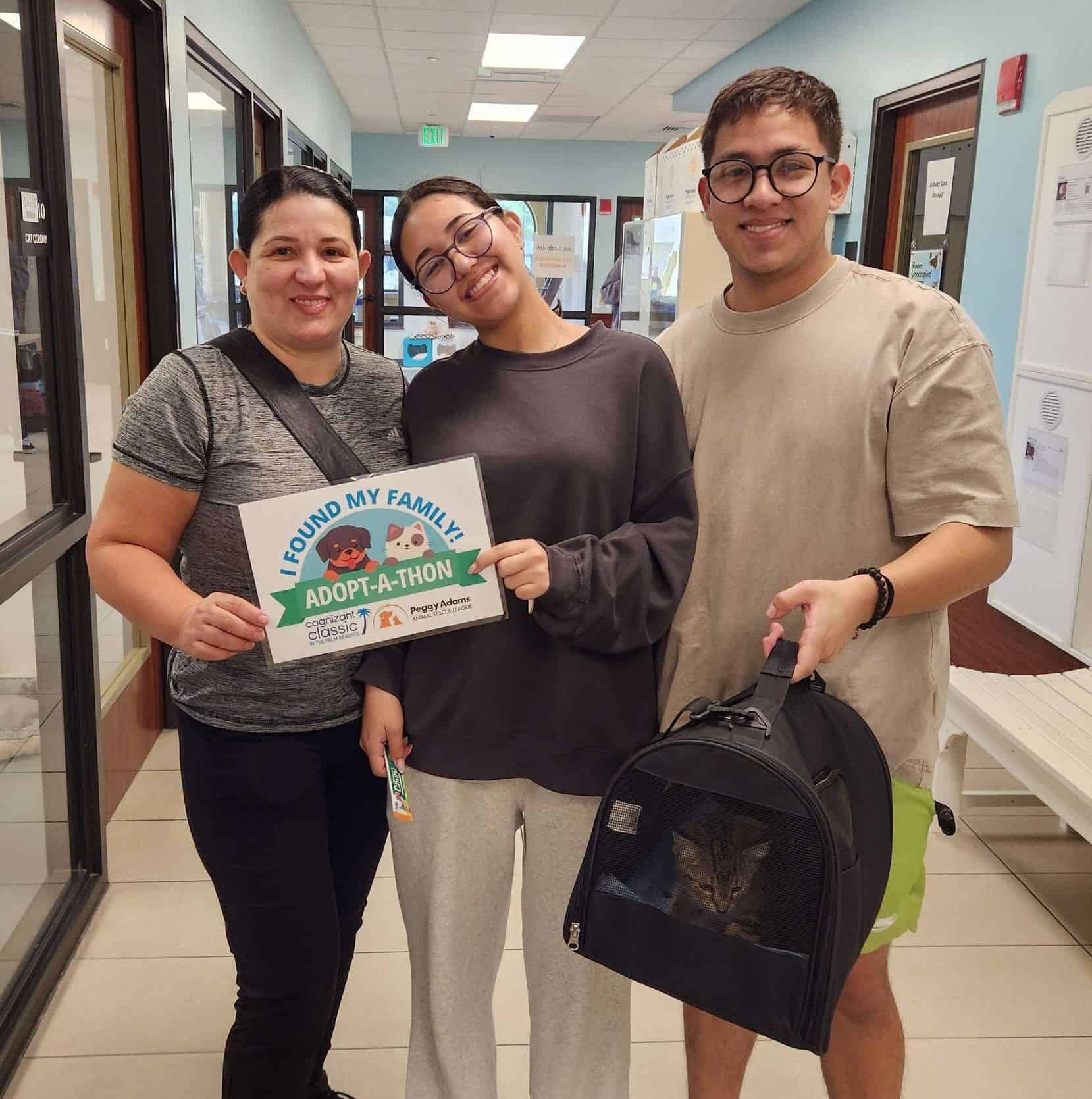 Happy adopters with their new pet at Peggy Adams Animal Rescue.