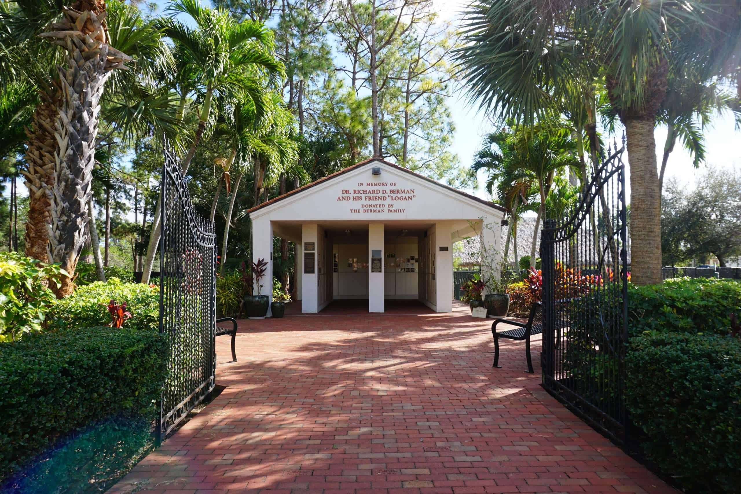 Entrada a Peggy Adams Animal Rescue League con exuberante vegetación y puertas abiertas.