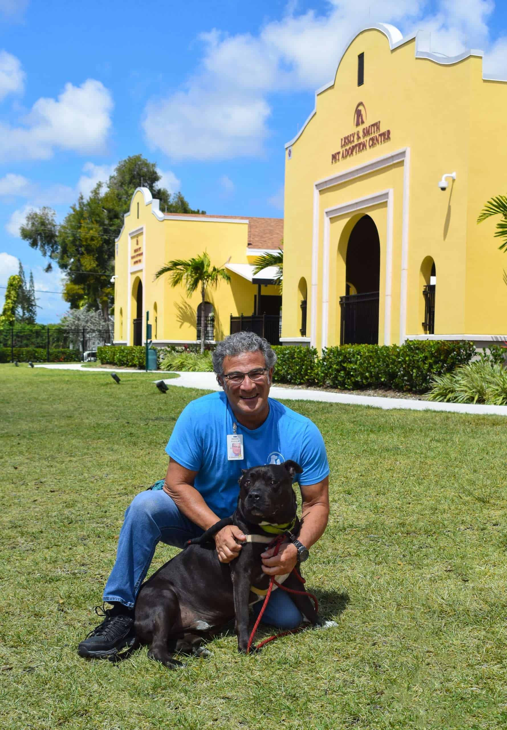Adopta un perro de Peggy Adams Animal Rescue en Florida, presentando a un hombre feliz con un perro negro afuera.
