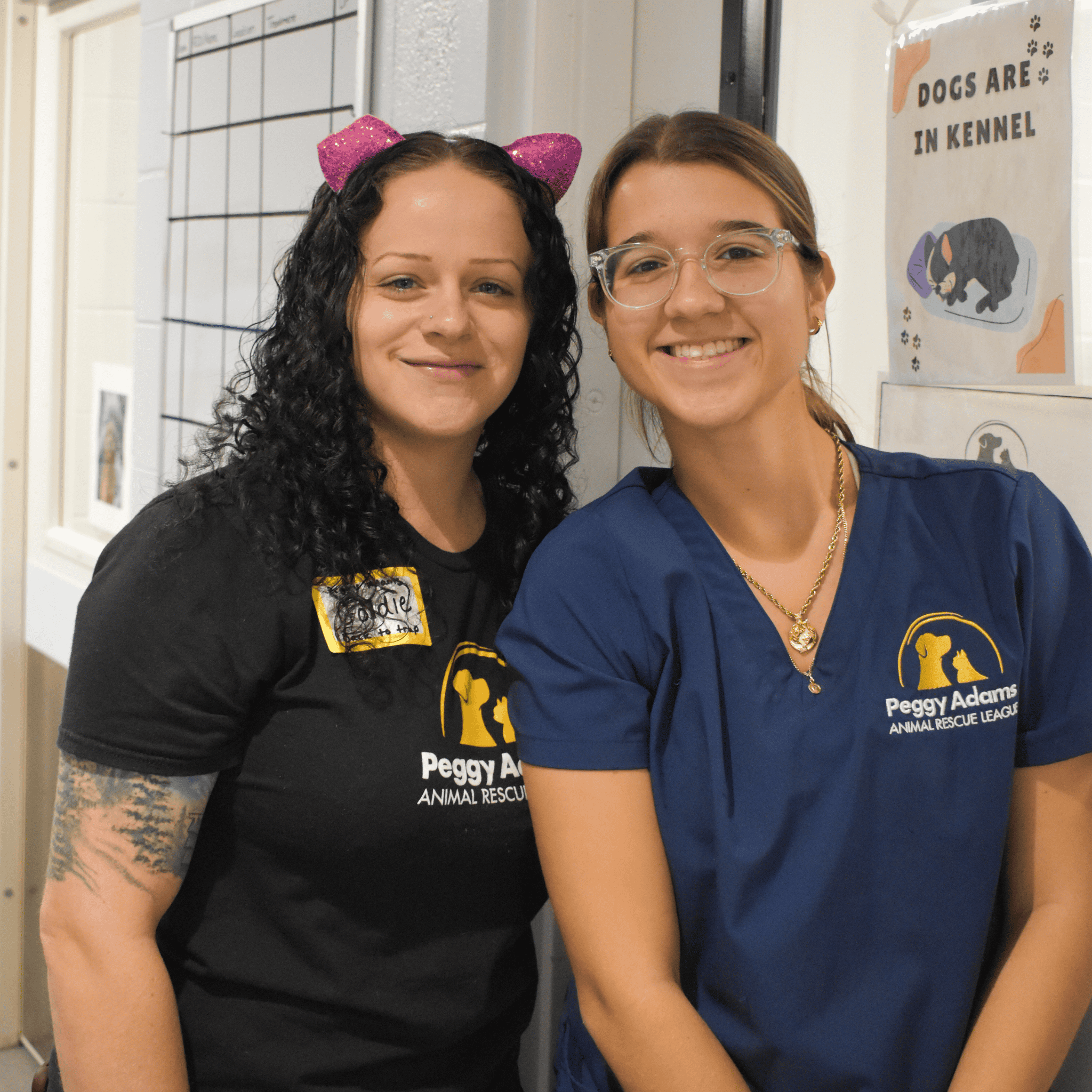 Two women staff members at Peggy Adams Animal Rescue League smiling in shelter.