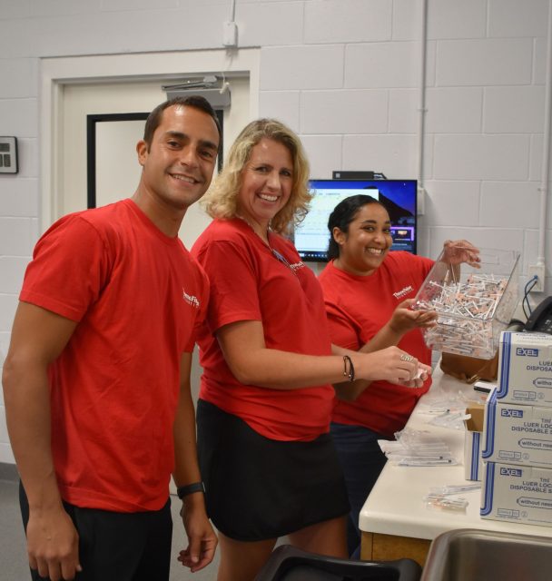 Happy staff members at Peggy Adams Animal Rescue with medical supplies.